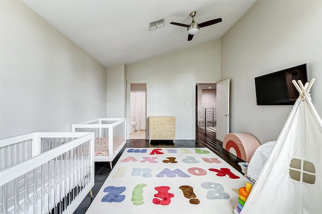 bedroom featuring vaulted ceiling, dark wood finished floors, visible vents, and a ceiling fan