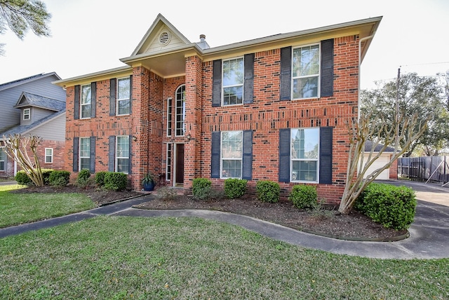 view of front facade with brick siding, a garage, and a front yard