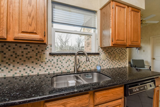 kitchen with brown cabinets, a sink, dark stone countertops, backsplash, and dishwasher