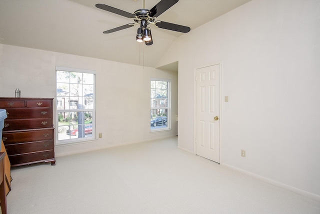 carpeted bedroom featuring lofted ceiling, multiple windows, a ceiling fan, and baseboards