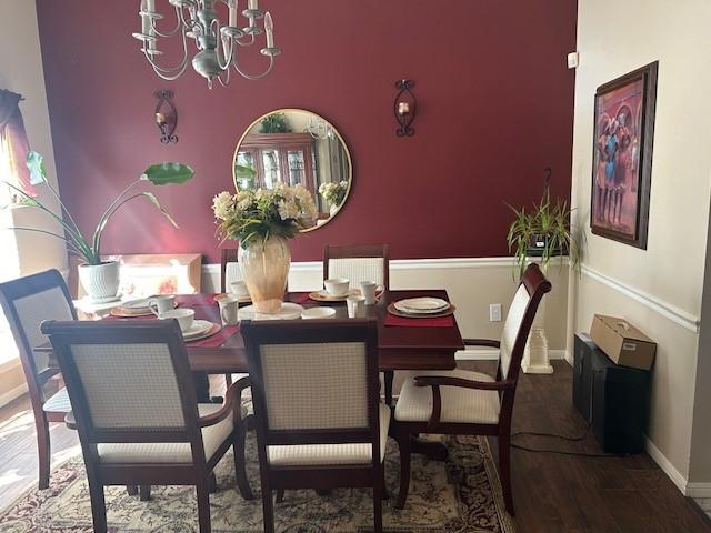 dining room with an inviting chandelier, baseboards, and wood finished floors