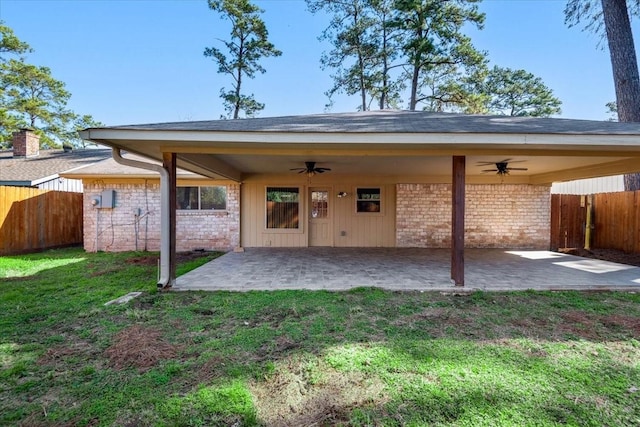 rear view of house with a patio area, a fenced backyard, a yard, and ceiling fan