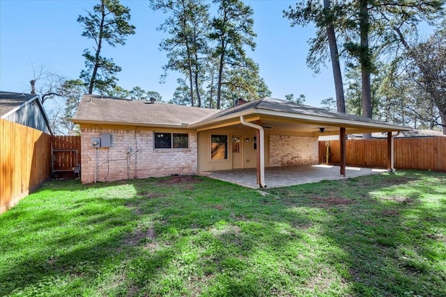 rear view of house featuring a patio, a lawn, and a fenced backyard