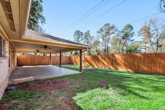 view of yard with a ceiling fan, a fenced backyard, and a patio