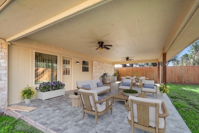 view of patio featuring ceiling fan, fence, an outdoor living space, and outdoor dining space