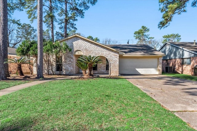 view of front of house featuring a front yard, concrete driveway, brick siding, and an attached garage