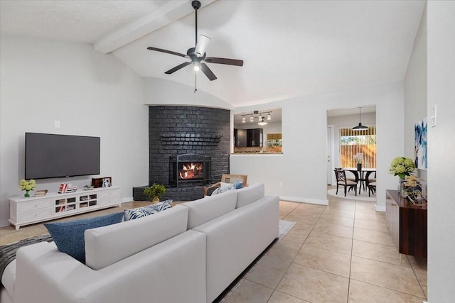 living room featuring light tile patterned floors, baseboards, a ceiling fan, vaulted ceiling with beams, and a brick fireplace