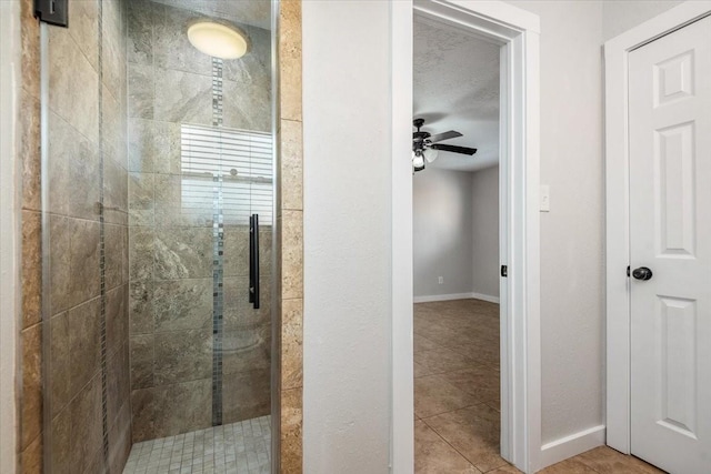 full bathroom with baseboards, a shower stall, a ceiling fan, and tile patterned floors