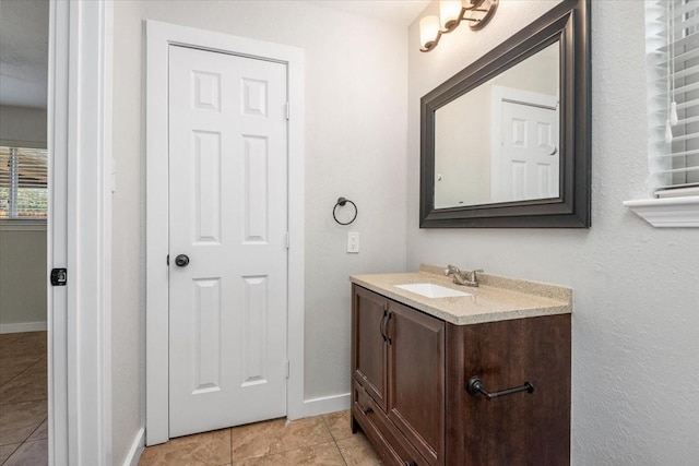 bathroom with tile patterned flooring, vanity, and baseboards