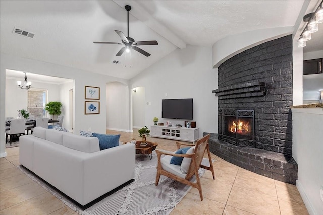 living room with visible vents, arched walkways, vaulted ceiling with beams, a brick fireplace, and light tile patterned flooring