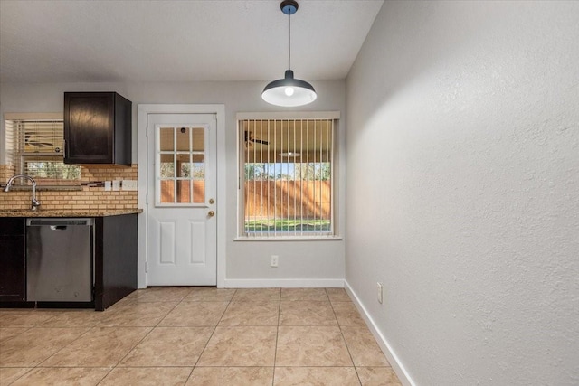 entryway featuring light tile patterned floors, a sink, and baseboards