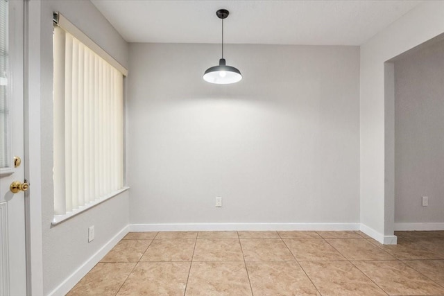 unfurnished dining area featuring light tile patterned floors and baseboards