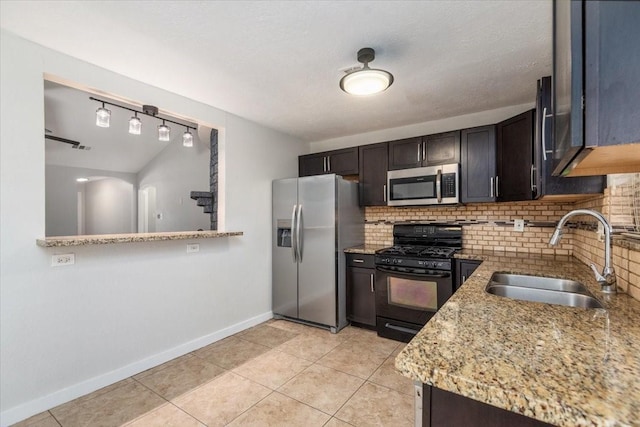 kitchen featuring light tile patterned floors, tasteful backsplash, stainless steel appliances, and a sink