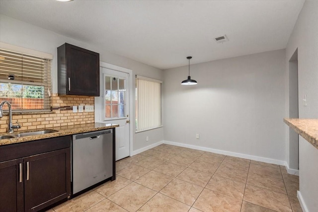 kitchen featuring tasteful backsplash, dishwasher, a sink, and light stone countertops