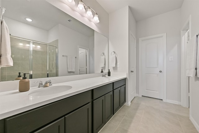 bathroom with a stall shower, tile patterned flooring, a sink, and double vanity