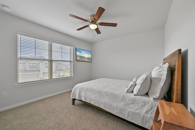 bedroom with ceiling fan, carpet flooring, and baseboards