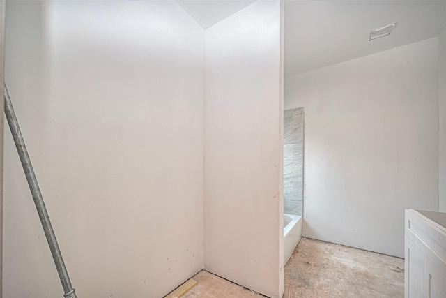 full bathroom with concrete floors and a bath