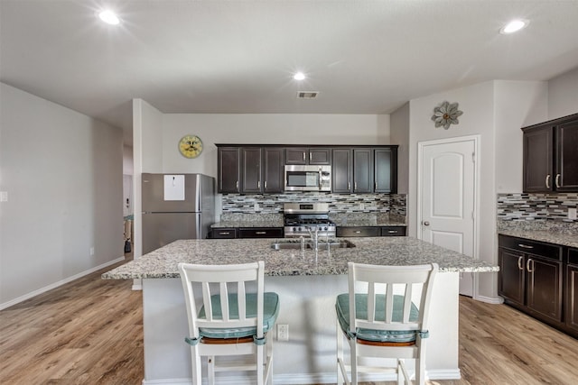 kitchen featuring light wood-style floors, visible vents, stainless steel appliances, and a sink