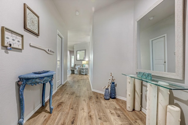 hallway featuring baseboards and wood finished floors