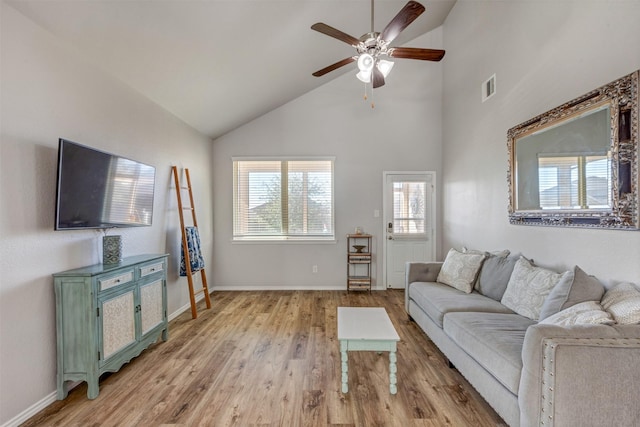 living room featuring ceiling fan, light wood-type flooring, visible vents, and baseboards