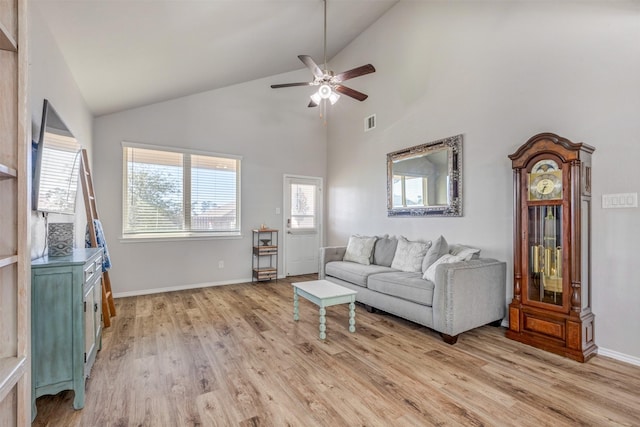 living area with visible vents, baseboards, ceiling fan, light wood-style floors, and high vaulted ceiling