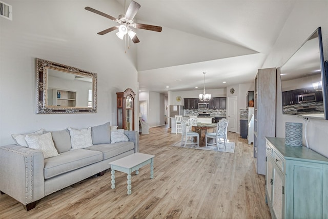 living room with recessed lighting, visible vents, light wood-style floors, high vaulted ceiling, and ceiling fan with notable chandelier