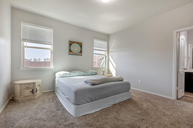 bedroom featuring carpet floors, baseboards, and ensuite bathroom