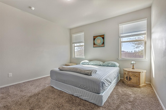 bedroom featuring light colored carpet and baseboards