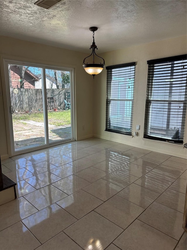 empty room featuring baseboards and a textured ceiling