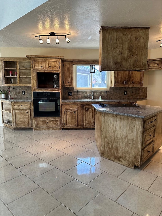 kitchen with a textured ceiling, light tile patterned flooring, a sink, backsplash, and black appliances