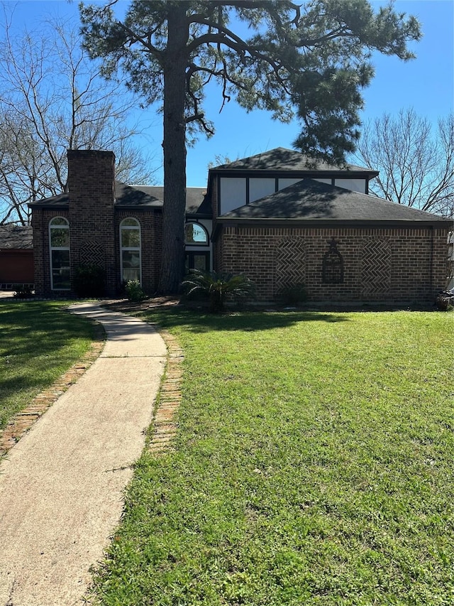 view of front of house featuring brick siding and a front lawn