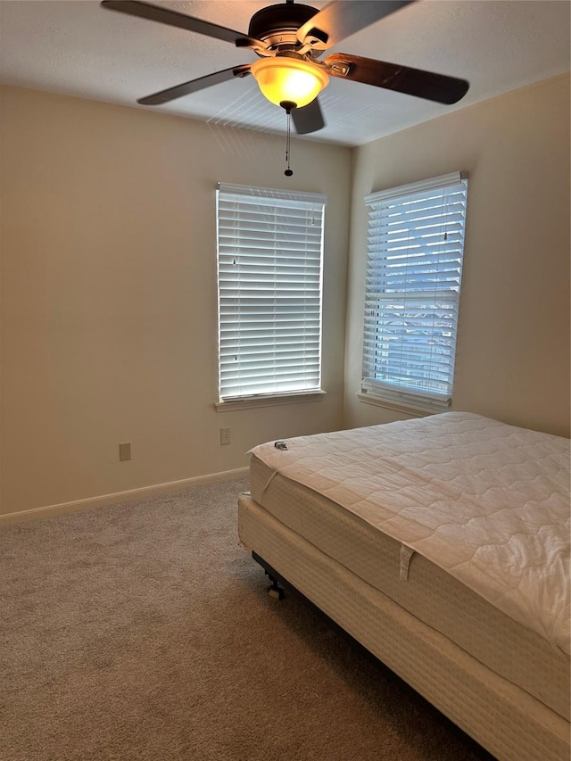 unfurnished bedroom with carpet floors, baseboards, and a ceiling fan