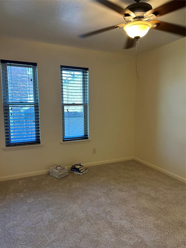 unfurnished room with ceiling fan, baseboards, and carpet flooring