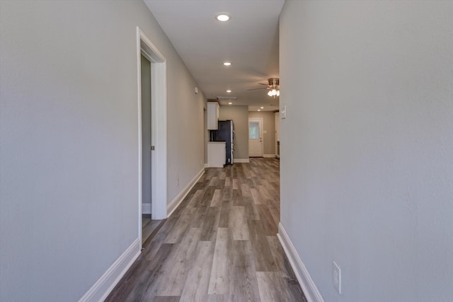 hall featuring recessed lighting, wood finished floors, and baseboards