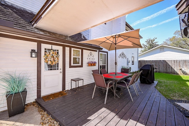 wooden terrace with outdoor dining area, a lawn, area for grilling, and fence