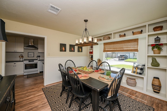 dining room with visible vents, a wainscoted wall, a notable chandelier, and dark wood finished floors