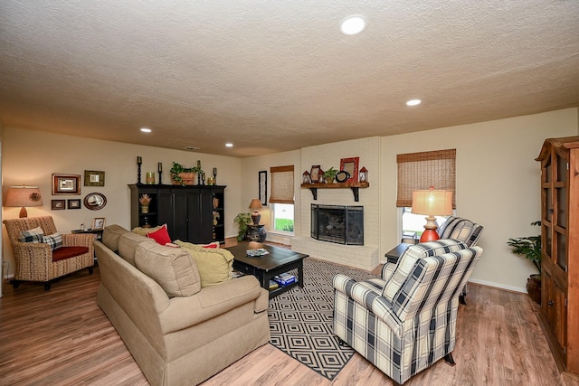 living room featuring recessed lighting, a fireplace, and wood finished floors