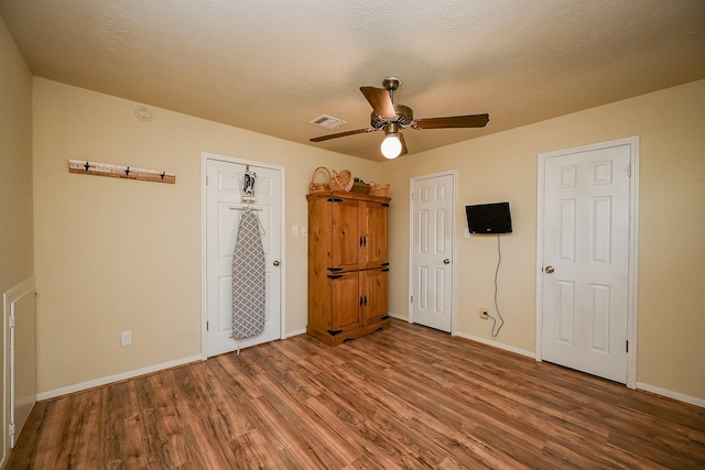 unfurnished bedroom featuring visible vents, baseboards, wood finished floors, a textured ceiling, and a ceiling fan