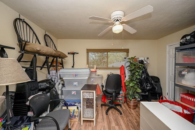 office area with a textured ceiling, a ceiling fan, and wood finished floors