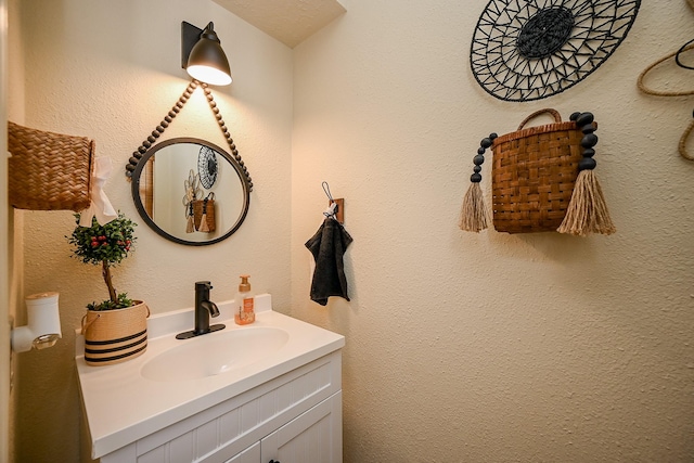 bathroom with vanity and a textured wall