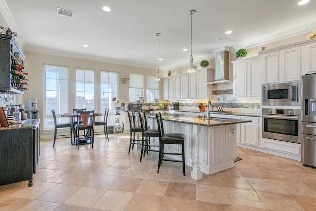 kitchen featuring visible vents, decorative backsplash, wall chimney exhaust hood, stainless steel appliances, and stone counters