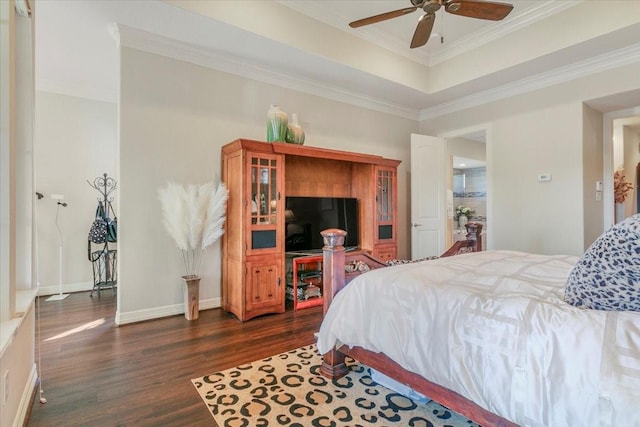 bedroom featuring baseboards, dark wood finished floors, a ceiling fan, a raised ceiling, and crown molding