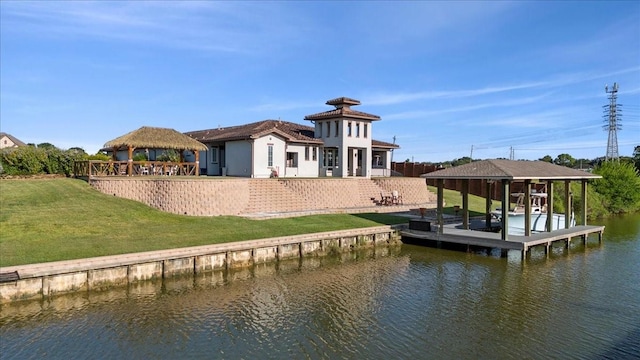 back of house featuring a water view, a lawn, boat lift, and a gazebo