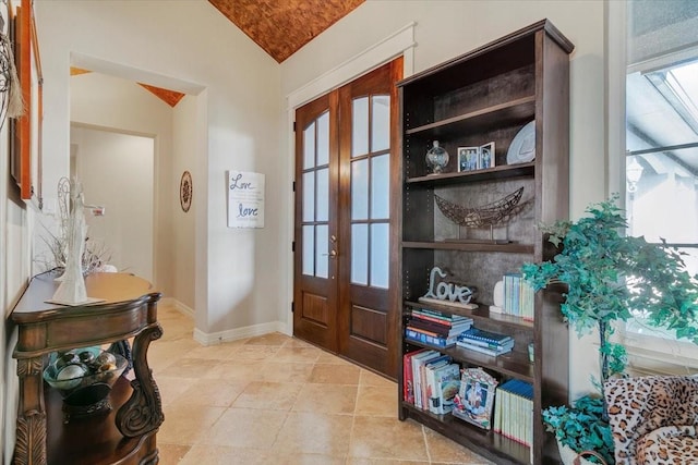 entrance foyer featuring lofted ceiling, tile patterned floors, baseboards, and french doors