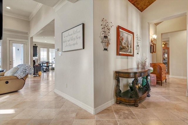 hallway featuring light tile patterned floors, baseboards, and ornamental molding