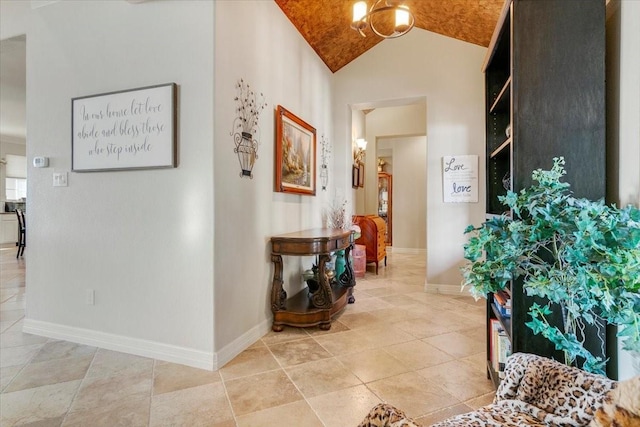 hall with vaulted ceiling and baseboards