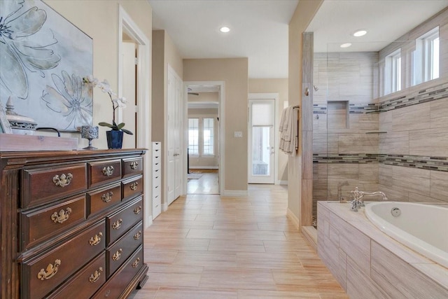 full bathroom featuring recessed lighting, vanity, baseboards, tiled shower, and a bath