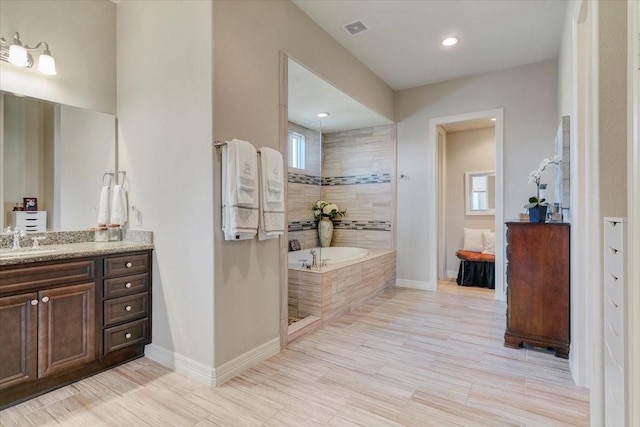 bathroom featuring a bath, vanity, visible vents, and baseboards