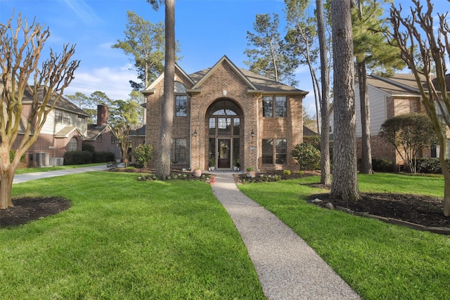 view of front of home featuring brick siding and a front lawn