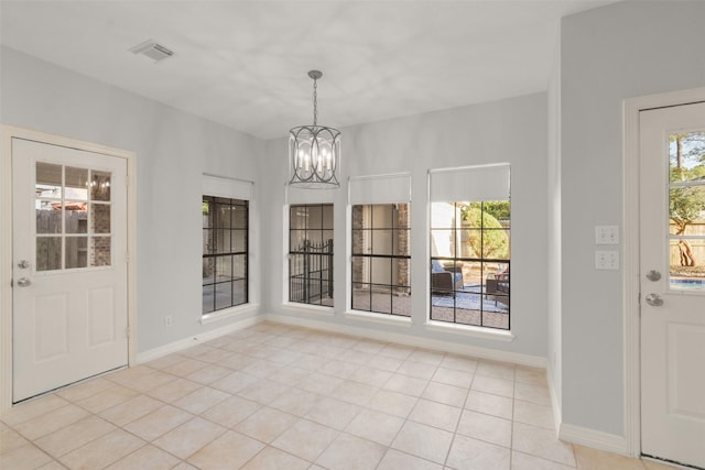 unfurnished dining area with an inviting chandelier, baseboards, visible vents, and light tile patterned flooring